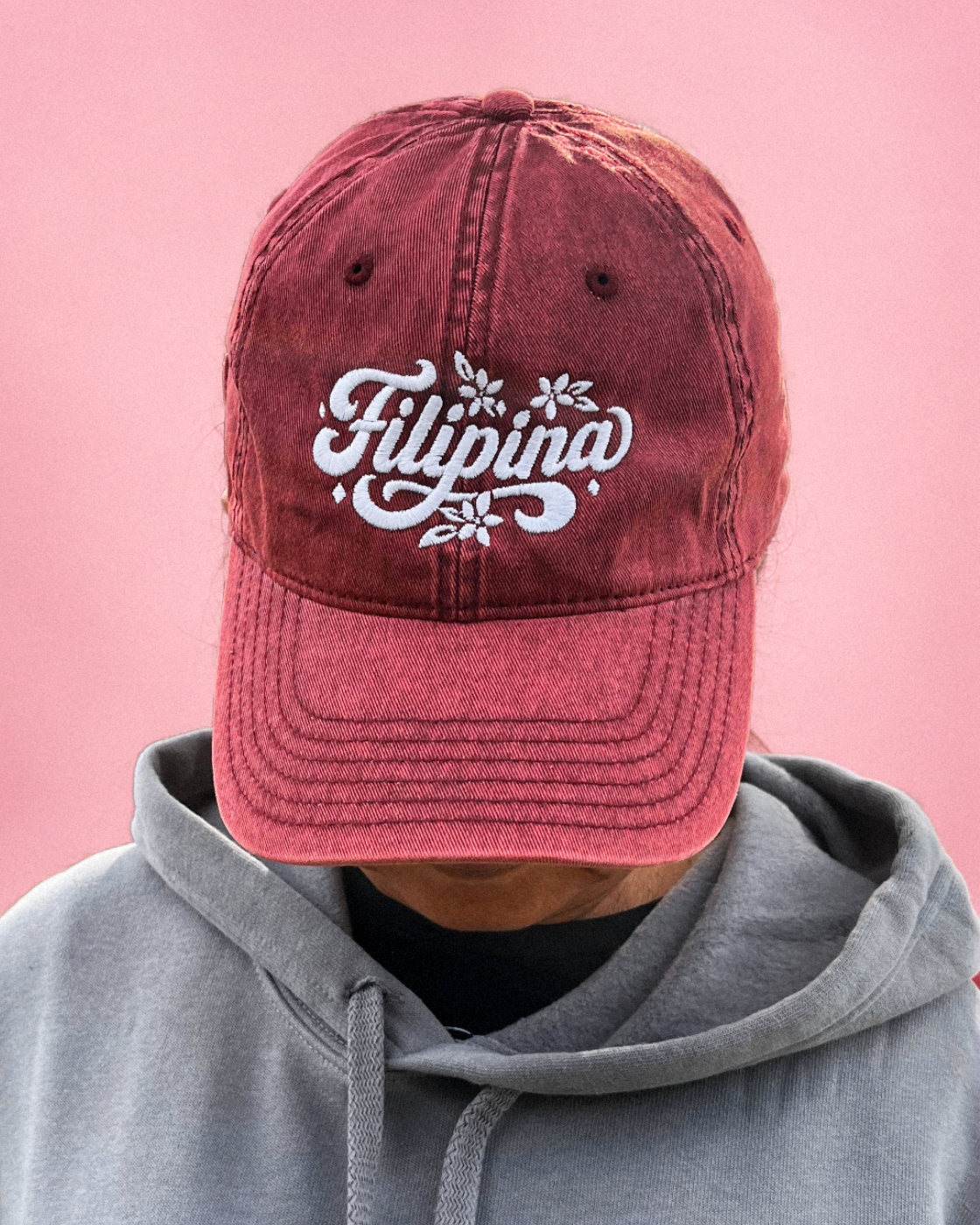 A woman wearing a maroon Filipina vintage cap.