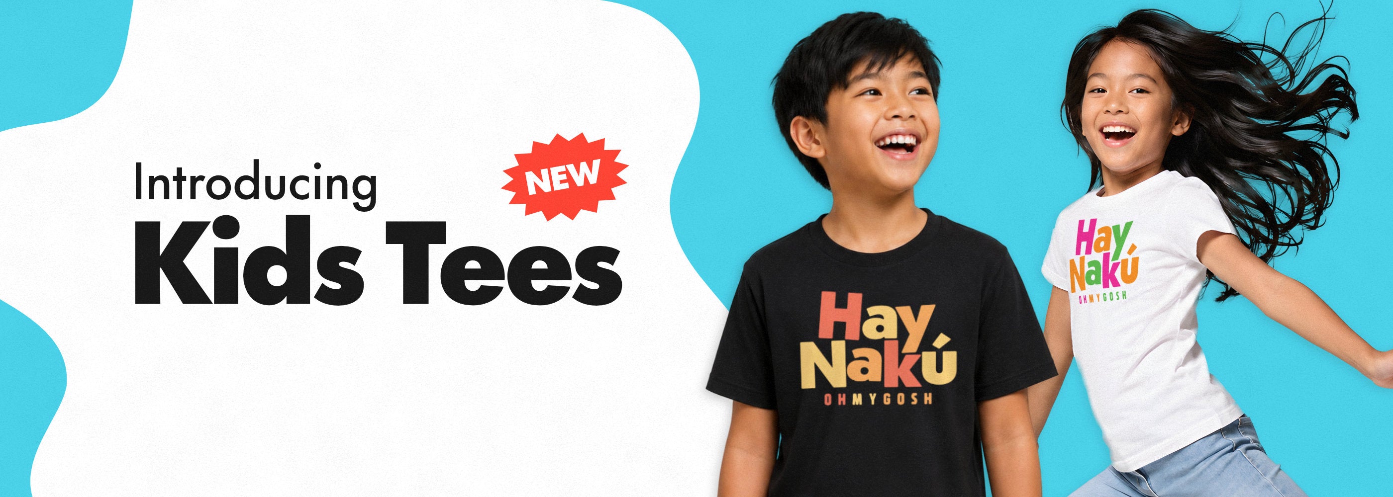 Promotional graphic for kids tees showing two children smiling and wearing the same colorful 'Hay Nakú' t-shirt design. One child wears a black version and the other wears a white version, set against a bright blue and white background with the text 'Introducing Kids Tees' and a red 'NEW' badge.